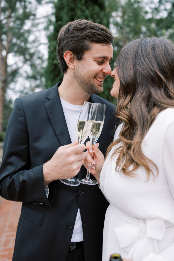 Couple celebrating their engagement by drinking champagne at Balboa Park.