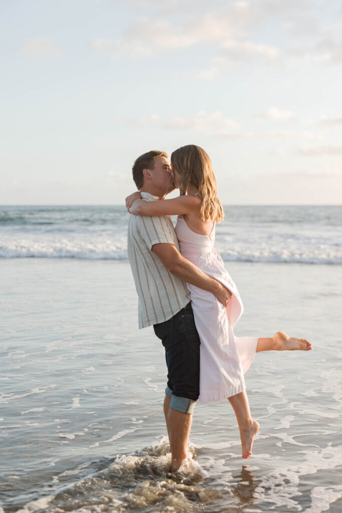 Couple sharing a kiss in the ocean at Coronado