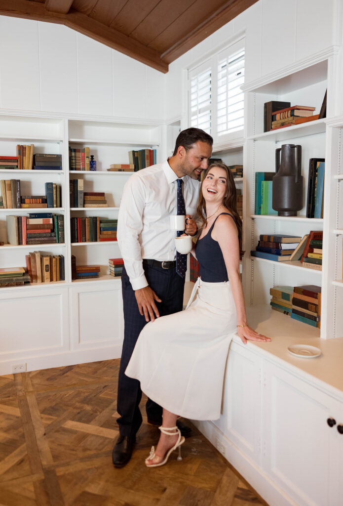 Engaged couple in the library at The Inn at Rancho Santa Fe, with shelves of books in the background.