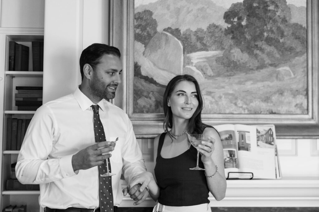 A couple standing by the fireplace in The Inn at Rancho Santa Fe’s library room