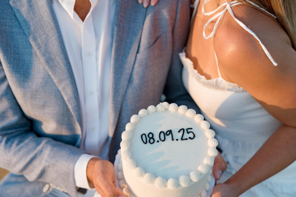 Couple hold a cake at their engagement session in La Jolla.