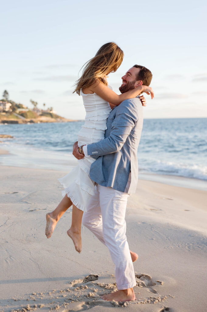 Couple dance together at their engagement session on Windansea Beach in La Jolla.