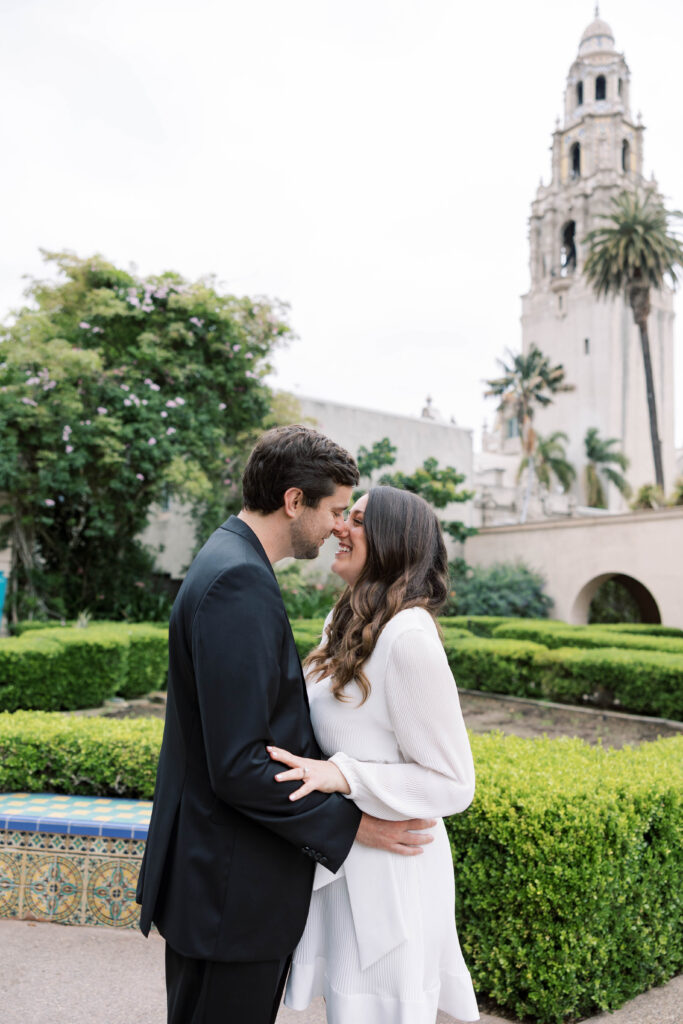 Engaged couple embracing during photoshoot at Balboa Park
