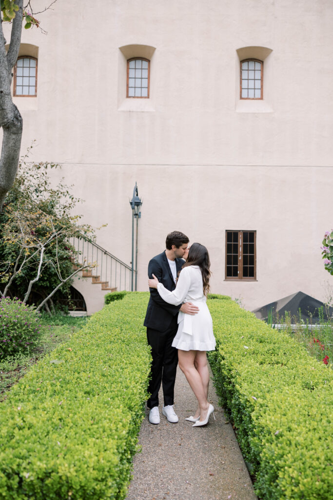Engaged couple kissing in engagement photo at Balboa Park, San Diego