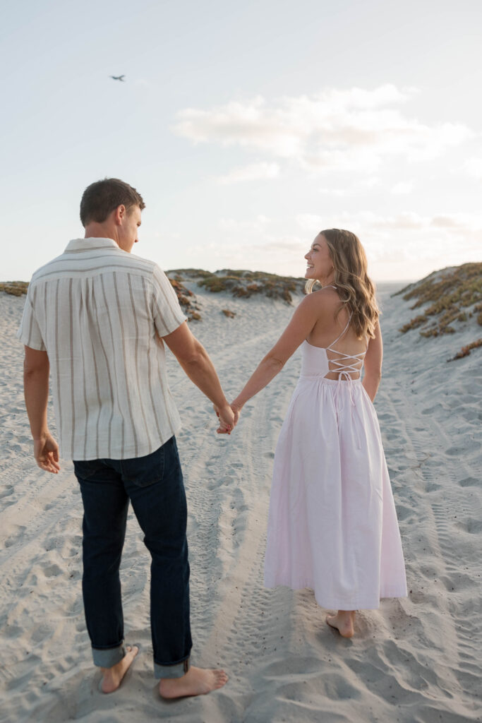 Couple holding hands and laughing at Coronado Sand Dunes