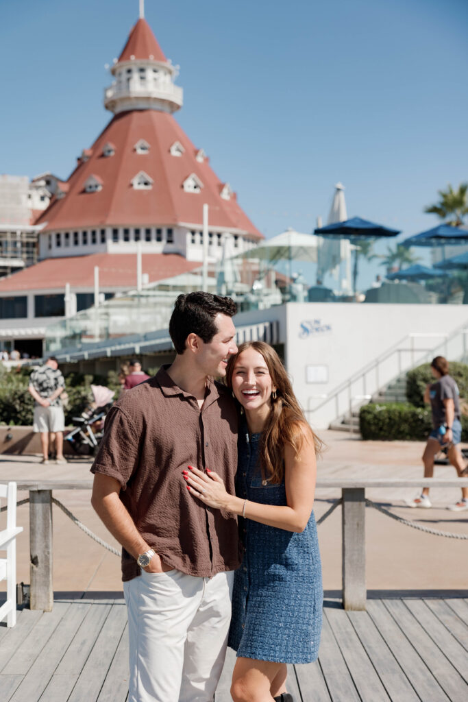 Newly engaged couple smiling and embracing at Hotel Del Coronado