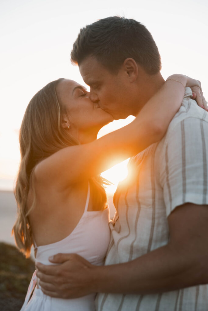 Couple kissing at Coronado Sand Dunes during golden hour