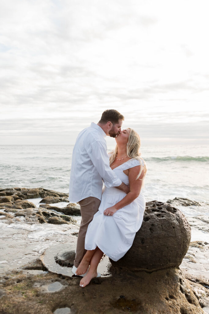 Engaged couple kissing at Sunset Cliffs in San Diego
