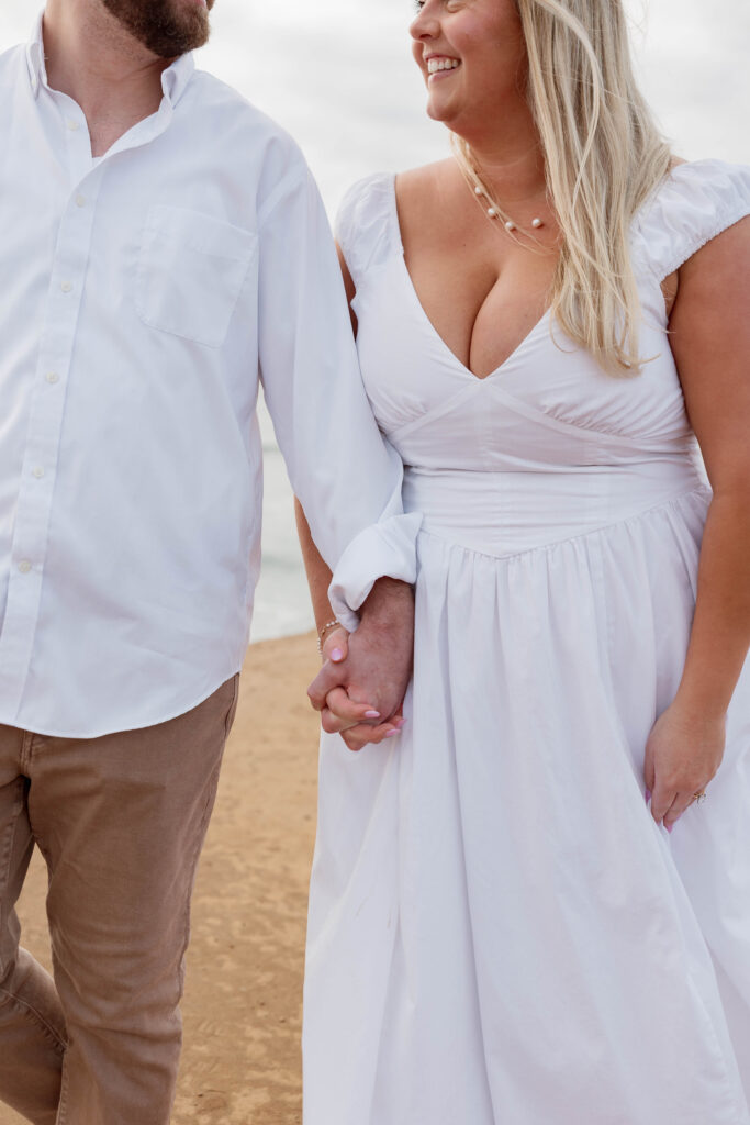 Engaged couple holding hands at Sunset Cliffs in San Diego