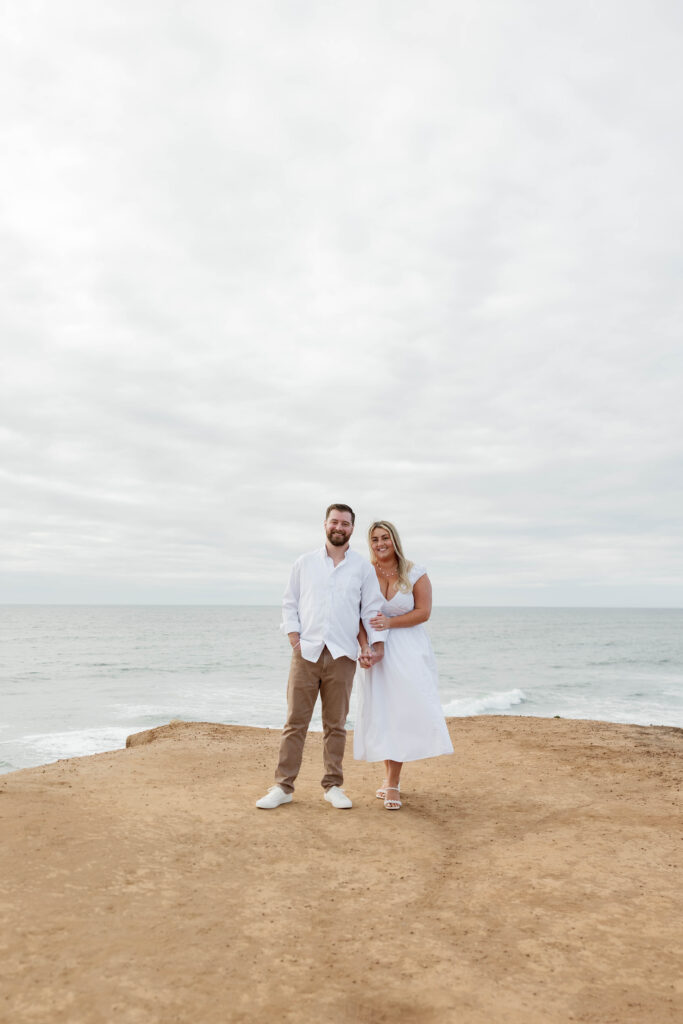 Engaged couple holding hands at Sunset Cliffs in San Diego