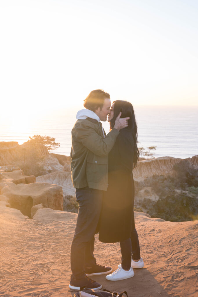 Couple kissing at proposal at Torrey Pines in San Diego