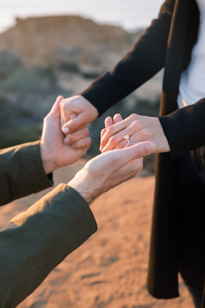 Close up of hands and engagement ring at Torrey Pines