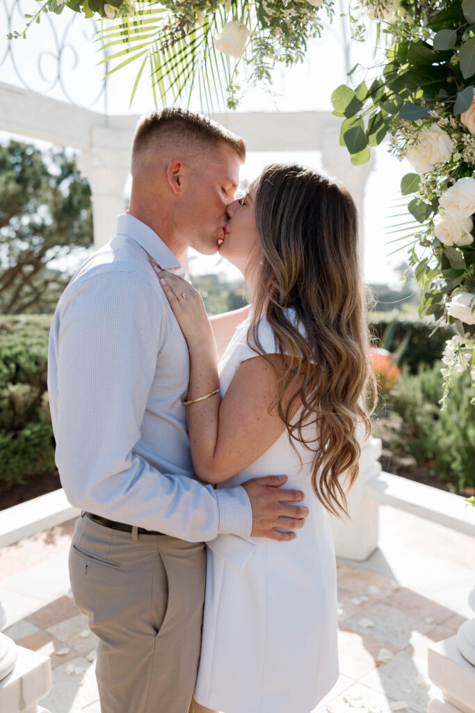 Newly engaged couple kissing under gazebo at Waldorf Astoria Garden