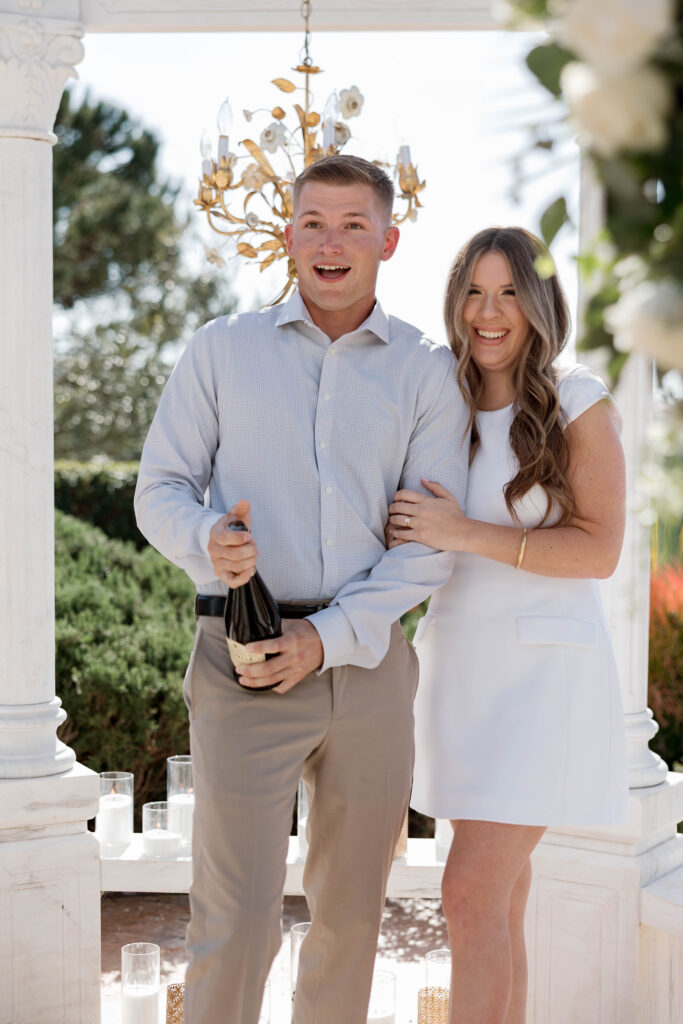 Popping champagne after proposal at Waldorf Astoria Garden