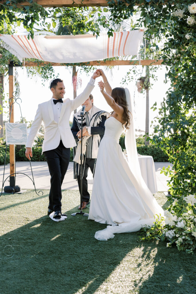 Bride and groom hold hands at wedding ceremony at Park Hyatt Aviara