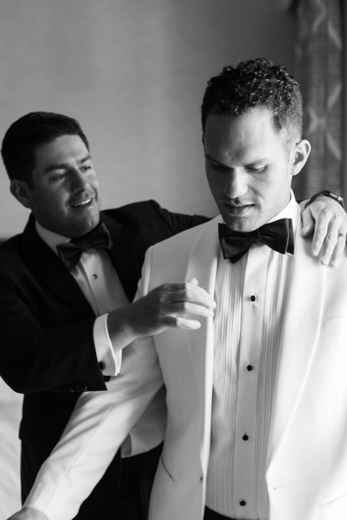 Groom getting dressed at Park Hyatt Aviara wedding in black and white