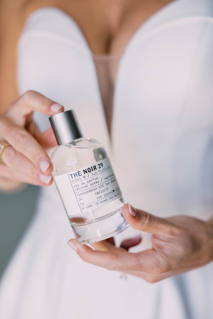 Bride holding perfume bottle at Park Hyatt Aviara in San Diego