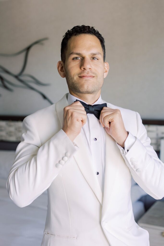 Groom in white suit and bowtie at Park Hyatt Aviara wedding