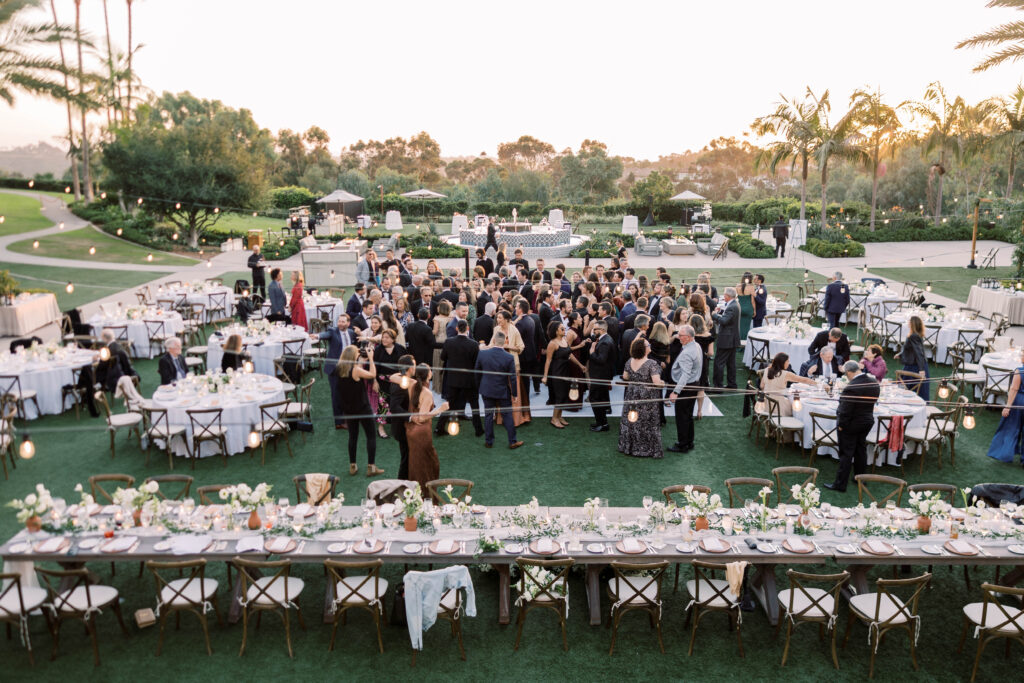 Outdoor wedding reception with guests at sunset at Park Hyatt Aviara