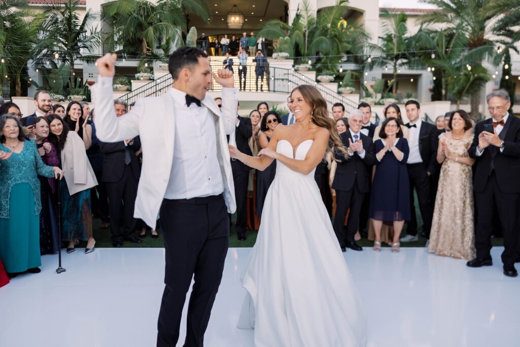 Bride and groom dance together as guests look on at Park Hyatt Aviara wedding reception