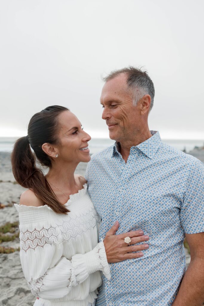 Parents smile at each other at Army Navy Beach