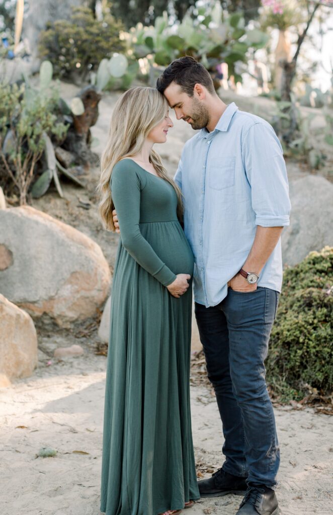 Pregnant couple hug at Balboa Park Desert Gardens
