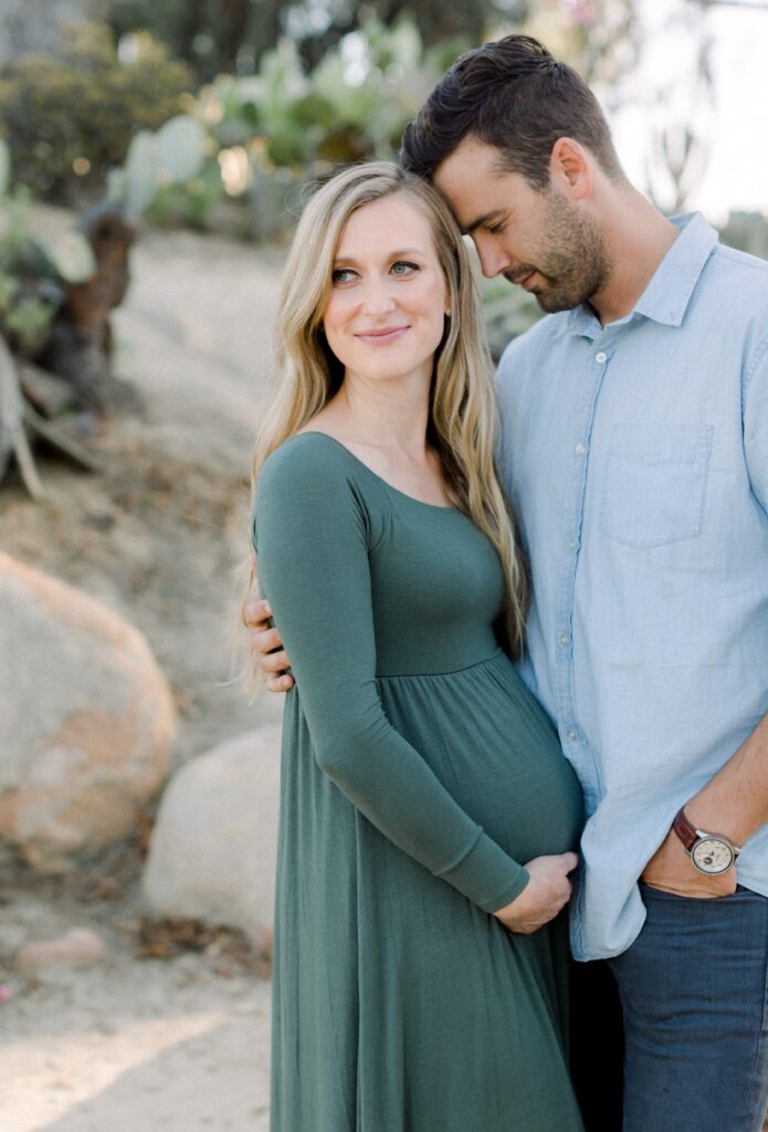 Pregnant couple pose together at Balboa Park Desert Gardens
