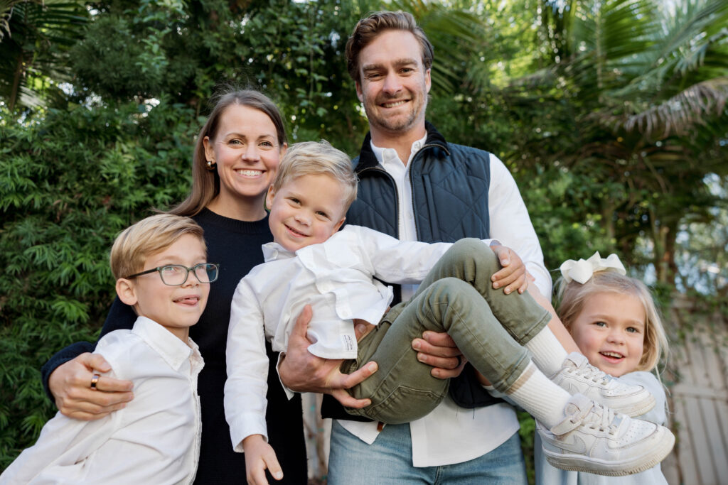 Family holds kids and smiles at camera in San Diego photoshoot