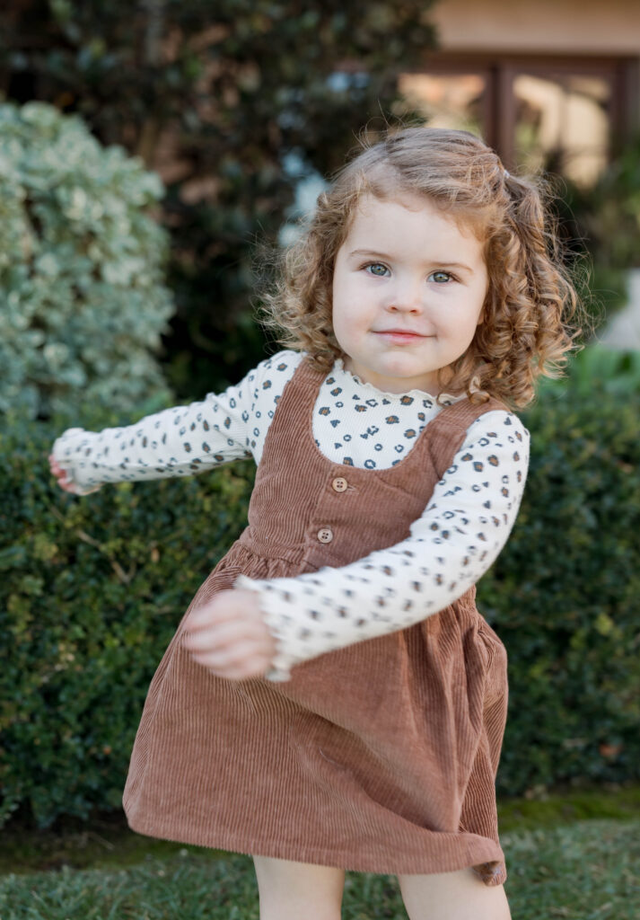 Little girl smiles at camera in San Diego family photoshoot