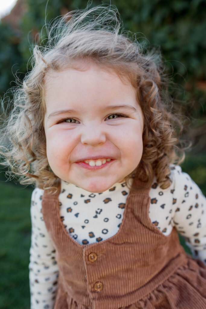 Smiling little girl laughs at camera