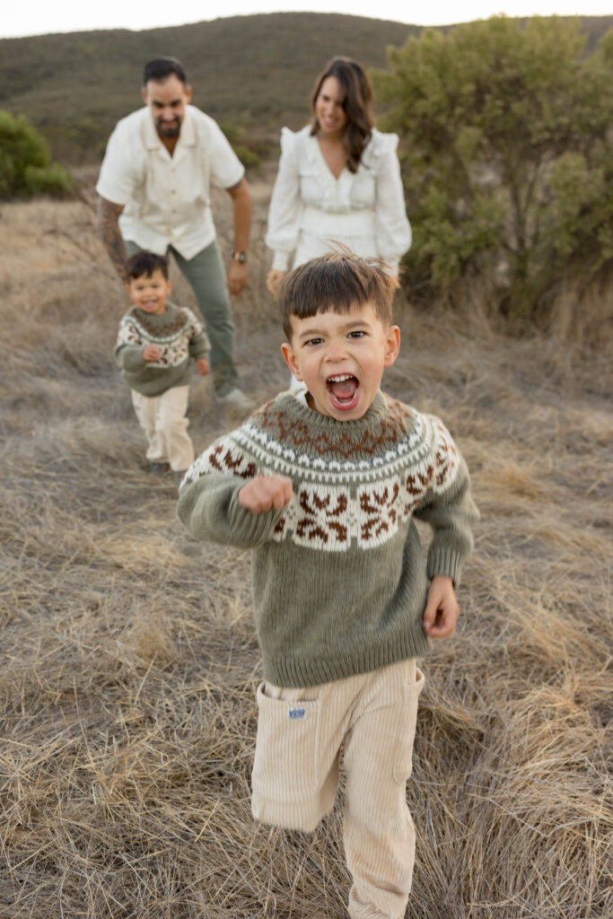 Kids running away from parents in San Elijo field